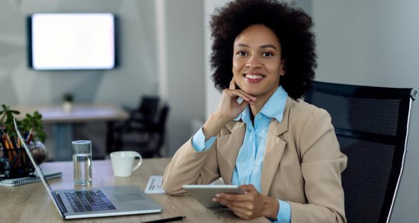 happy-african-american-businesswoman-working-touchpad-office